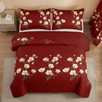 Overhead view of the red and yellow floral quilted bedspread with two matching pillow shams and a folded solid red reverse.
